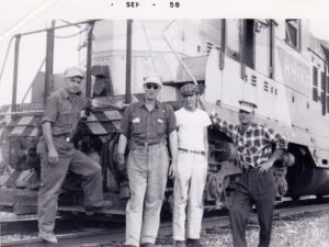 1958 Harry Becker (Engineer), Pat Hay (Front end Breakman), Alan Marshall (Student), James Kislanko (Tail end Brakeman), by their train in Empress